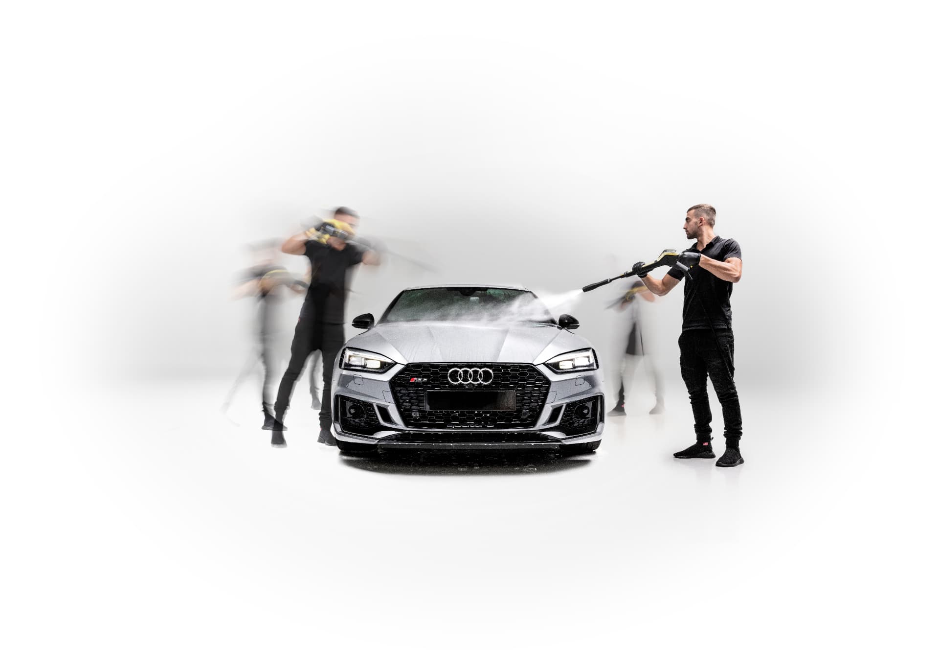 Carfē technicians pressure-washing a silver Audi RS5 in the Greenlane studio